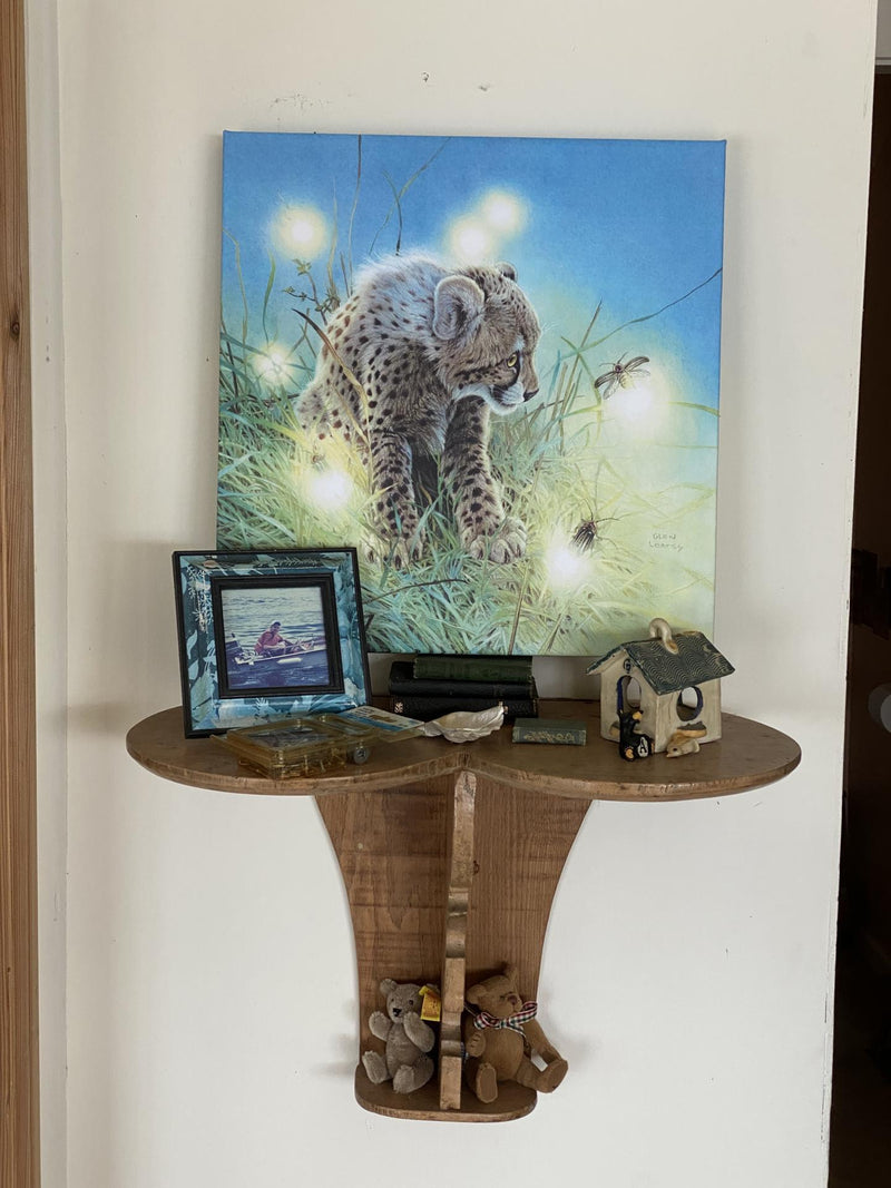 Young Cheetah with Fireflies canvas by Glen Loates above a side table